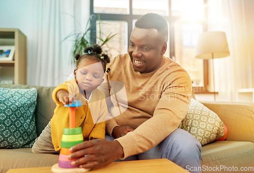 Image of african family playing with baby daughter at home