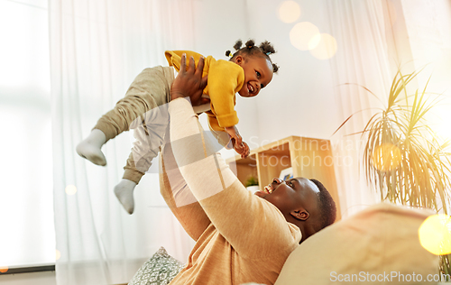 Image of happy african american father with baby at home