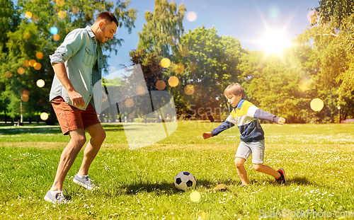 Image of father with little son playing soccer at park