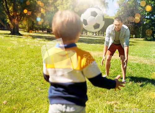 Image of father with little son playing soccer at park