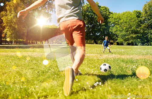 Image of father with little son playing soccer at park