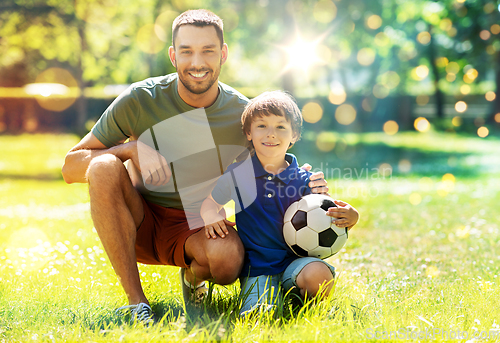 Image of father and little son with soccer ball at park