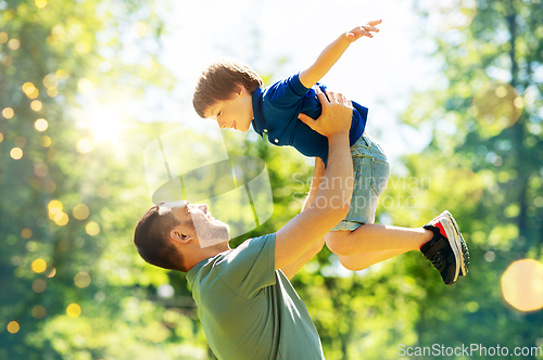 Image of happy father with son playing in summer park