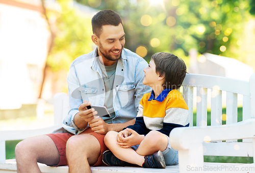 Image of father and son with smartphone at park