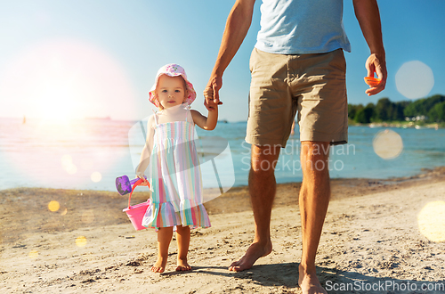 Image of father walking with little daughter on beach