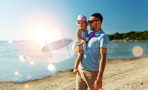 Image of happy father with little daughter on beach