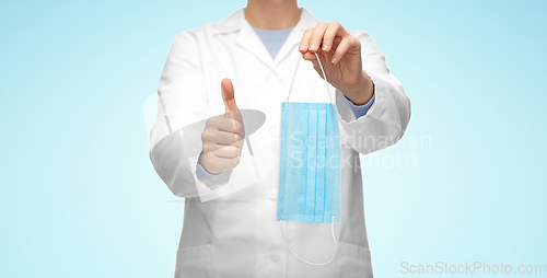 Image of female doctor with medical mask showing thumbs up