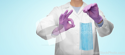 Image of female doctor with medical mask showing ok gesture