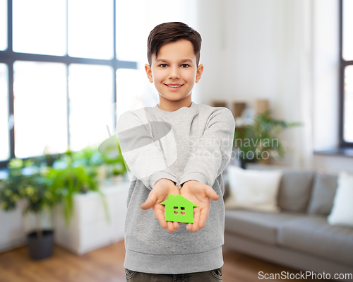 Image of smiling boy holding green house icon