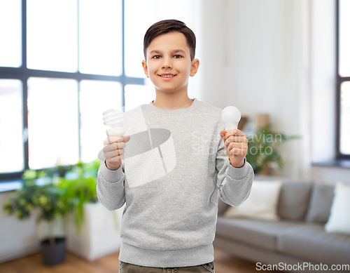 Image of smiling boy comparing different light bulbs