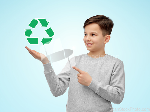 Image of smiling boy showing green recycling sign