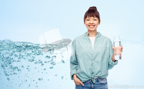 Image of happy asian woman holding glass bottle with water