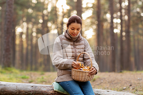 Image of woman with mushrooms in basket in autumn forest