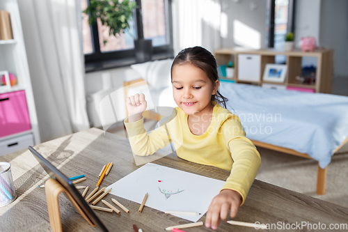 Image of little girl drawing with coloring pencils at home