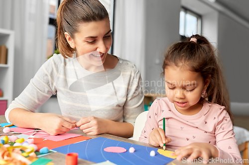 Image of daughter with mother making applique at home