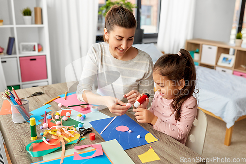 Image of daughter with mother making applique at home