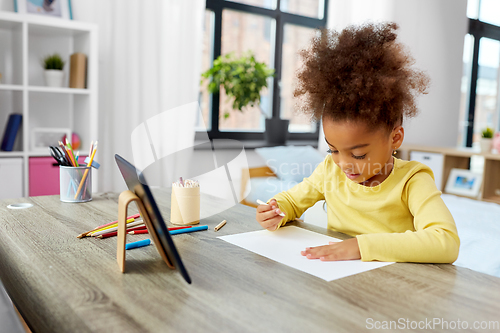 Image of little girl drawing with coloring pencils at home