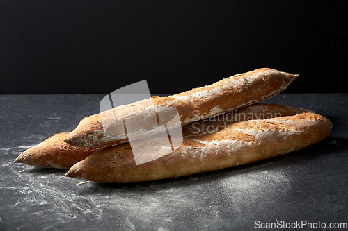 Image of baguette bread on table over dark background