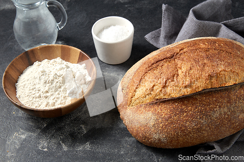 Image of bread, wheat flour, salt and water in glass jug