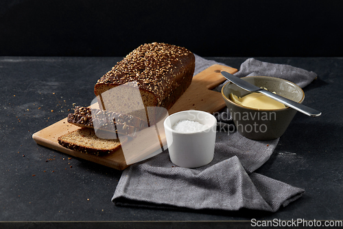 Image of close up of bread, butter, knife and salt on towel