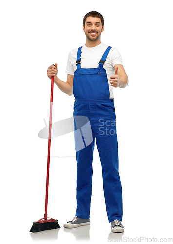 Image of male cleaner in overall cleaning floor with broom