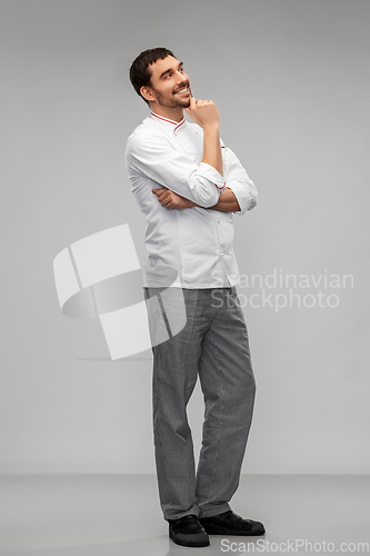 Image of happy smiling thinking male chef in toque