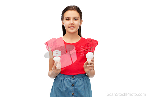 Image of smiling girl comparing different light bulbs