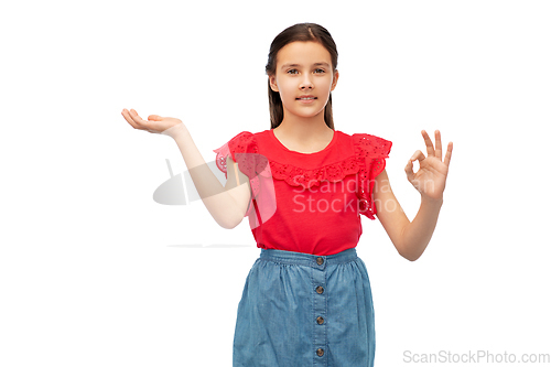 Image of girl holding something on hand and showing ok