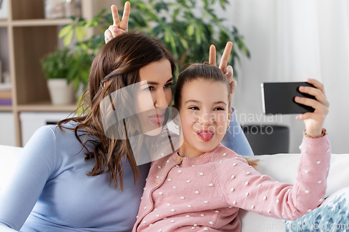 Image of happy family taking selfie by smartphone at home