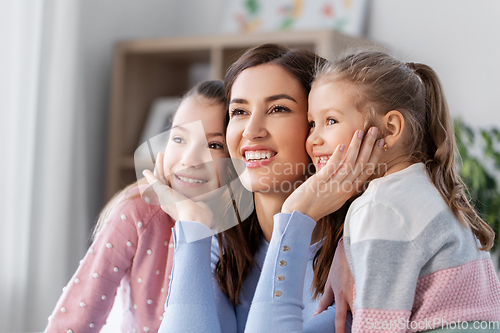 Image of happy smiling mother with two daughters at home
