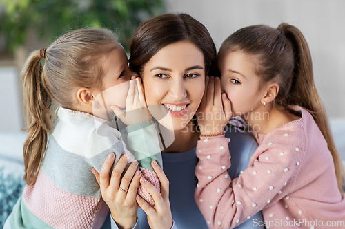 Image of happy mother and daughters gossiping at home