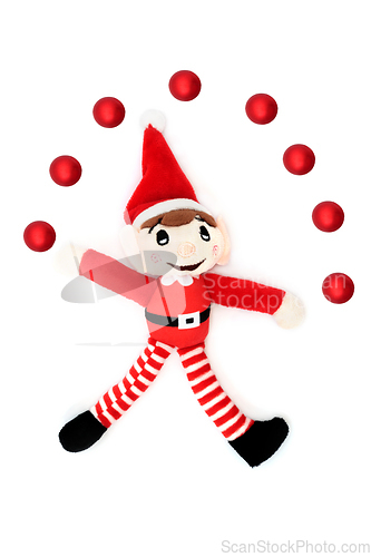 Image of Christmas Elf Juggling Fun with Red Bauble Ball Decorations