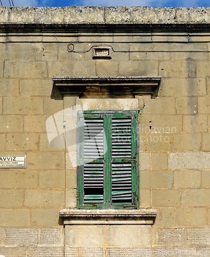 Image of Closed window of the old building covered by green wooden blinds in Rabat town on Malta