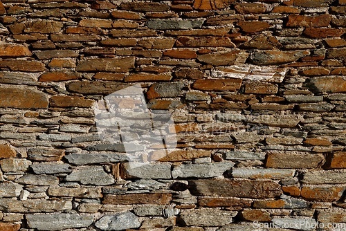 Image of Texture of old wall built of dark red bricks and stone blocks