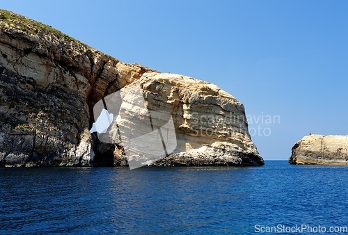 Image of Scenic rocks with a hole near Gozo island on Malta, on bright summer day