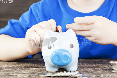 Image of boy lays in his piggy bank
