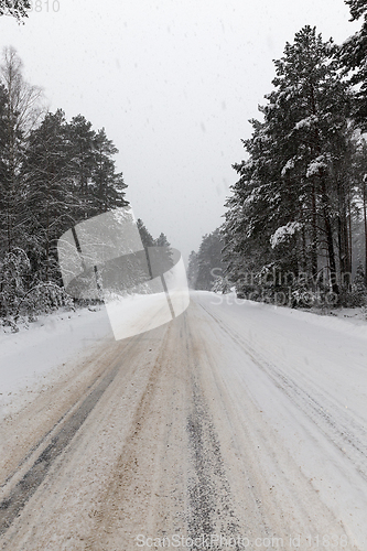 Image of a dirty, broken snow-covered road