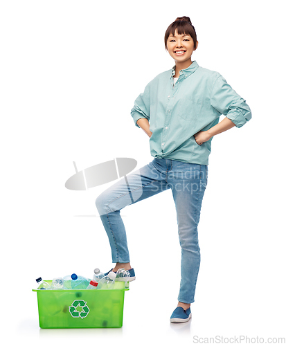 Image of smiling young asian woman sorting plastic waste