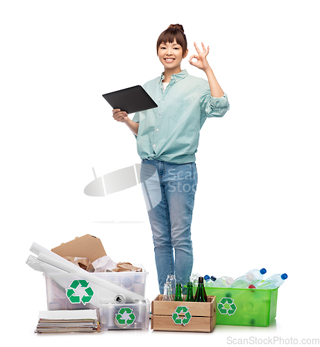 Image of smiling asian woman with tablet pc sorting waste