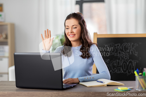 Image of teacher with laptop having online class at home