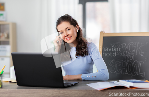 Image of teacher with laptop having online class at home