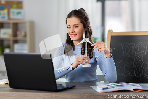 Image of teacher with laptop and windmill has online class