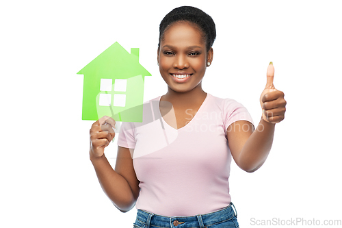 Image of smiling african american woman holding green house