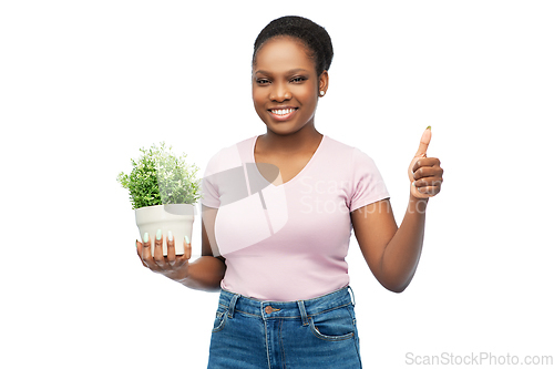 Image of happy african woman with flower showing thumbs up