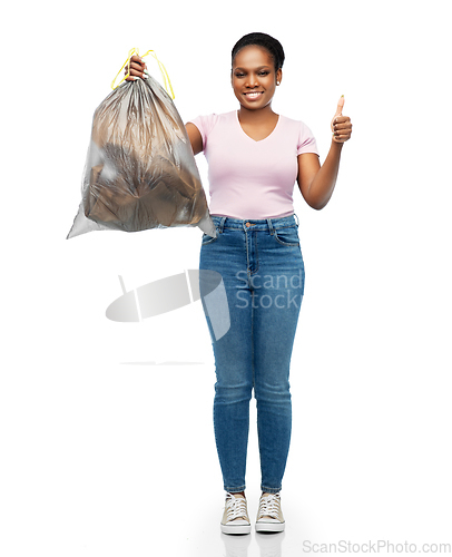 Image of smiling woman holding plastic trash bag with waste