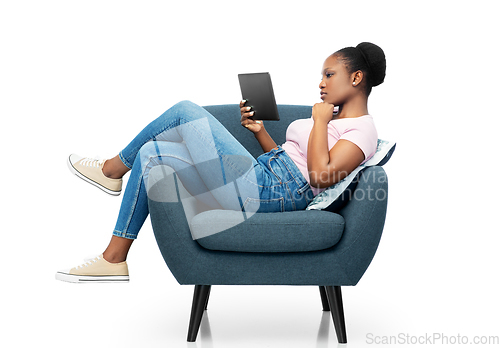 Image of woman with tablet pc sitting in armchair