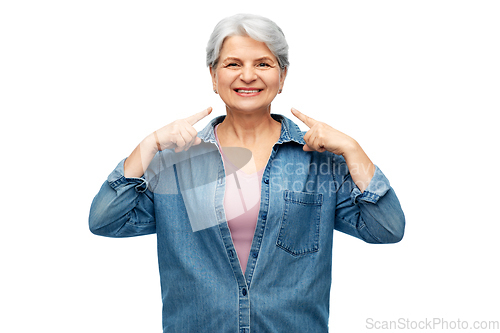Image of smiling senior woman showing to her face