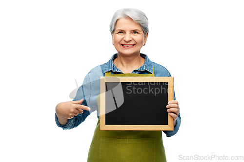 Image of happy senior woman in garden apron with chalkboard