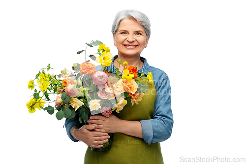 Image of smiling senior woman in garden apron with flowers