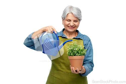 Image of senior gardener with flower and watering can